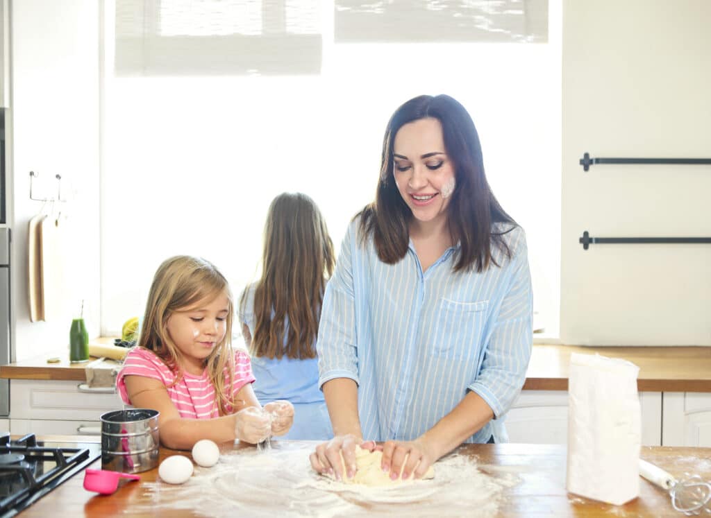 About 2 happy young mother and daughters pouring flour thr 2025 01 09 22 14 38 utc