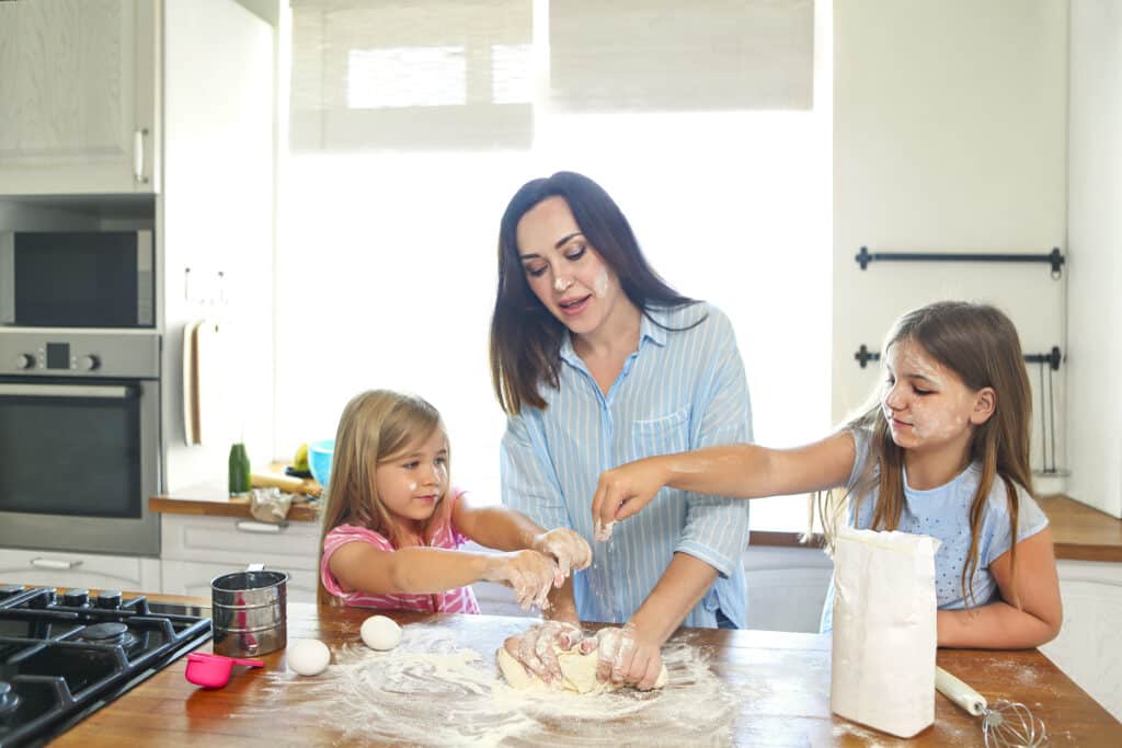 About 1 happy young mother and daughters pouring flour thr 2025 01 10 00 18 23 utc